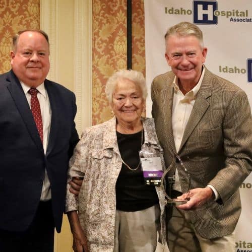 Idaho Hospital Association President Brian Whitlock, Janie Nirk, Idaho Governor Brad Little presents IHA award